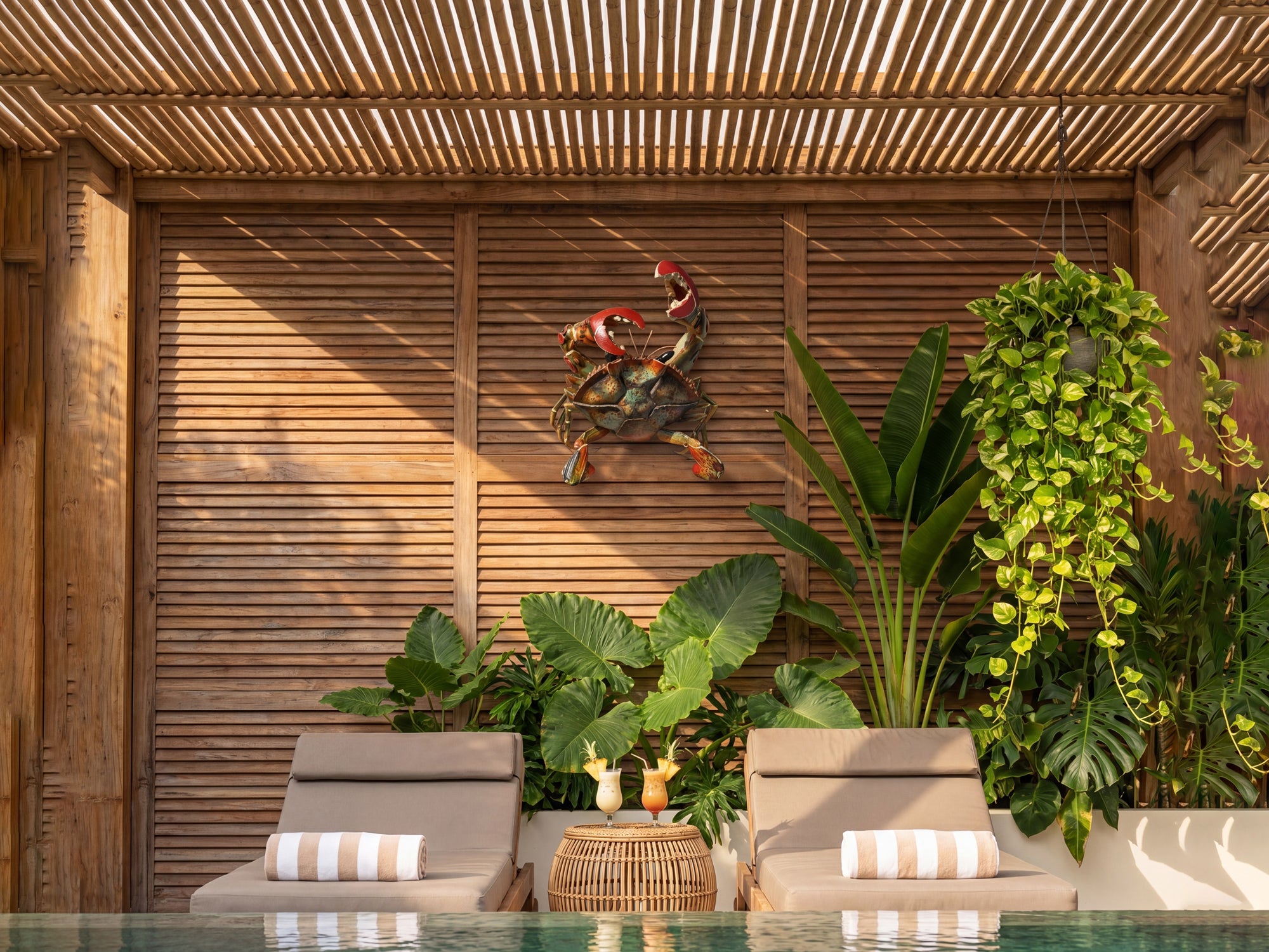 beach house crab wall decor in tropical outdoor patio with wooden panels and lounge chairs